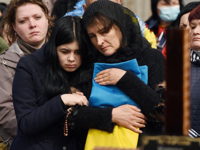 Relatives attend a ceremony at the funeral of the soldier Teodor Osadchyi, killed during the Russian invasion, at Lychakiv cemetery in Lviv, western Ukraine, on March 29, 2022. (Photo by Yuriy Dyachyshyn / AFP)