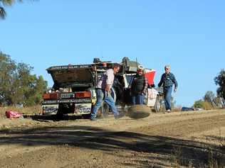 OFF-ROAD RALLY: Michael (left) and Juanita work to repair a flat tire during the start of their journey.