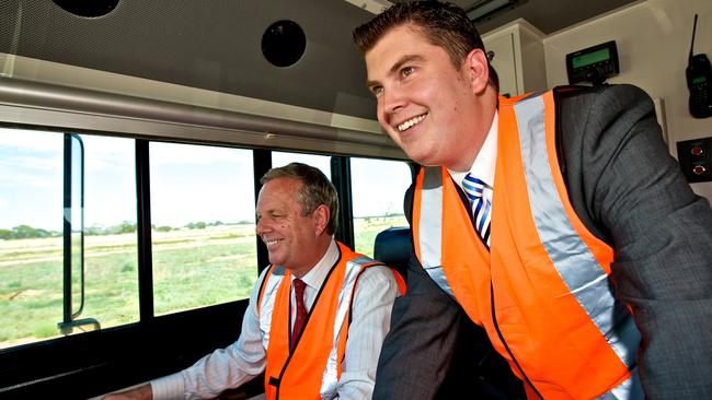 Former SA Premier Mike Rann with Playford Mayor Glenn Docherty in 2011 driving a freight train through the opening banner at the new rail freight terminal at Edinburgh Parks. Mr Rann first promised the electrification of the Gawler line in 2008.