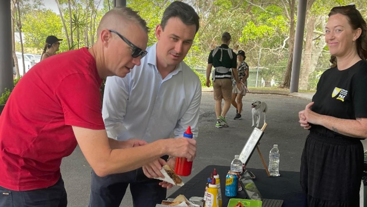 Bonney LNP MP Sam O'Connor buying a sausage at the Labrador State School polling booth with volunteer and community worker Jenna Schroeder. Picture: Paul Weston.