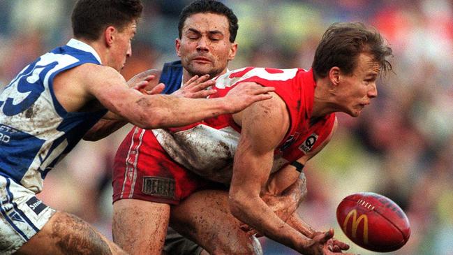 Sydney's Matthew Nicks handballs clear of Brent Harvey (29) and Peter Bell of North Melbourne in 1997. Nicks had a successful career with the Swans