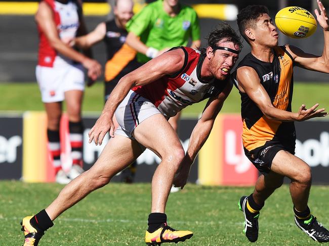 Tigers Ryan Mu tries to grip a loose footy as Districts Henry Armour misses the tackle during Saturday's game.