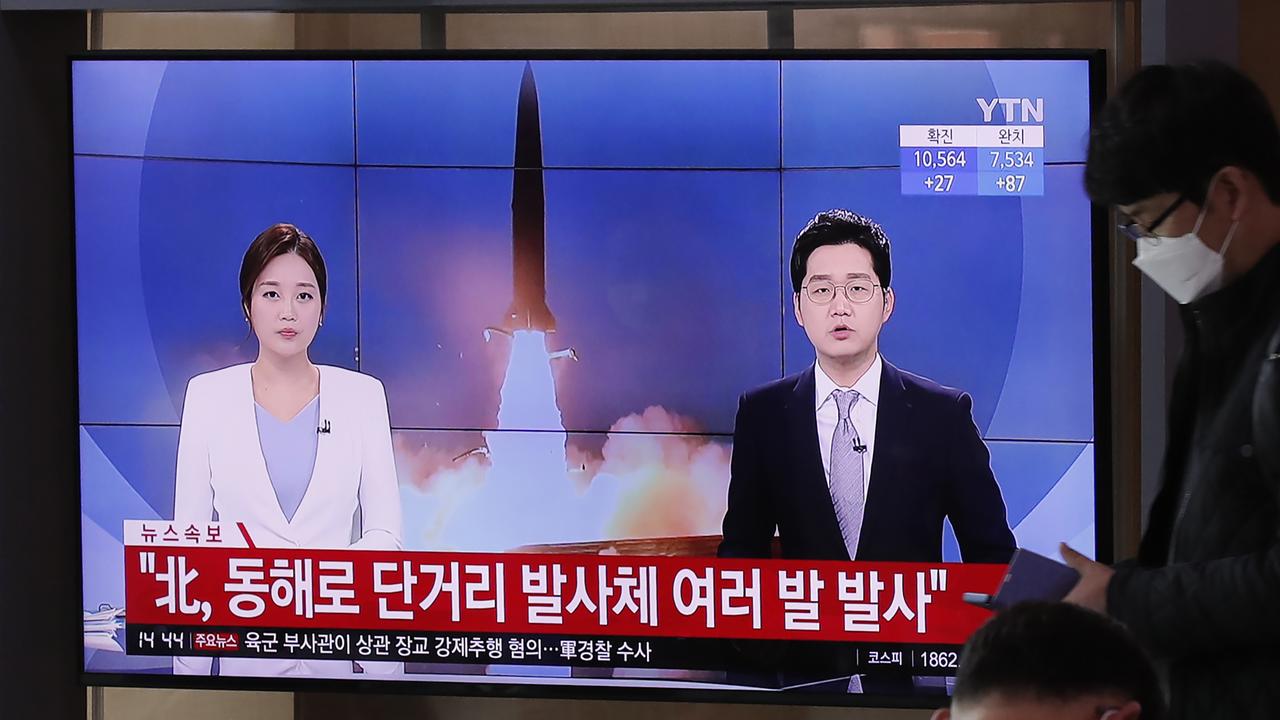 A man in Seoul wearing a face mask walks past a TV screen airing reports about North Korea’s firing of missiles. Picture: Lee Jin-man/AP