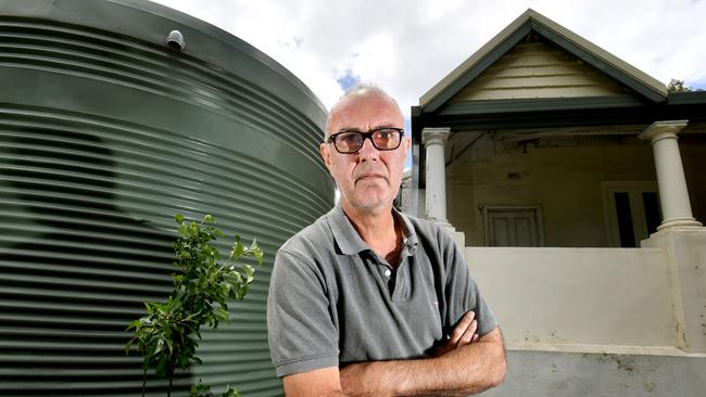 Magill resident Branko Soda with the rainwater tank installed by neighbour beside his house. Picture: Sam Wundke/AAP