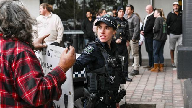 A police officer interacts with a person outside the centre. Picture: NewsWire / Brenton Edwards