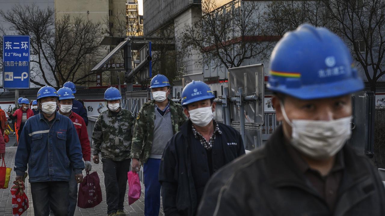 Construction workers wear protective masks as they leave a site at the end of the work day in Beijing, China. Picture: Kevin Frayer/Getty Images