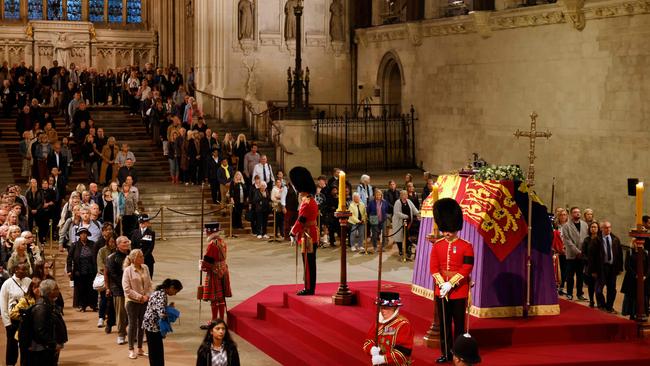 Members of the public pay their respects as they pass the coffin of Queen Elizabeth II. (Photo by Odd ANDERSEN / POOL / AFP)