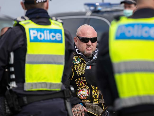 Comanchero Motorcycle Club President Mick Murray waits with other members to have their identification checked in Tooradin. Picture: Ian Currie