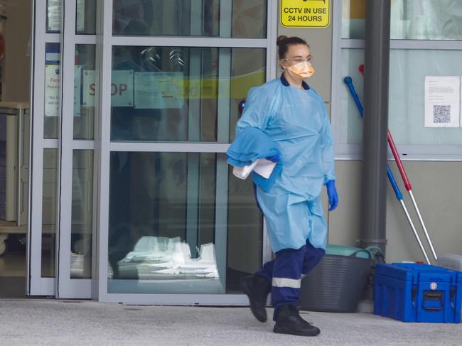 SYDNEY, AUSTRALIA - DECEMBER 28: A health worker walks through the ambulance entrance of Vincent's Hospital on December 28, 2021 in Sydney, Australia. COVID-19 testing clinics are at capacity in Sydney with increased demand and centres closing for public holidays.  (Photo by Jenny Evans/Getty Images)