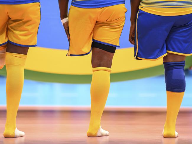 Rwanda sitting volleyball players align for the national anthem before their match against China