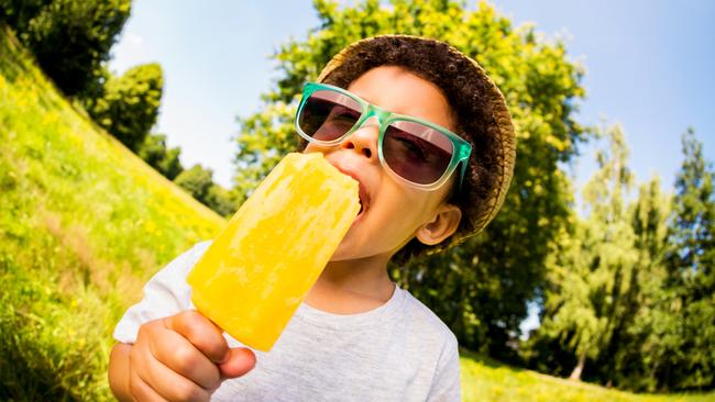 Little latino child enjoying a popsicle in park