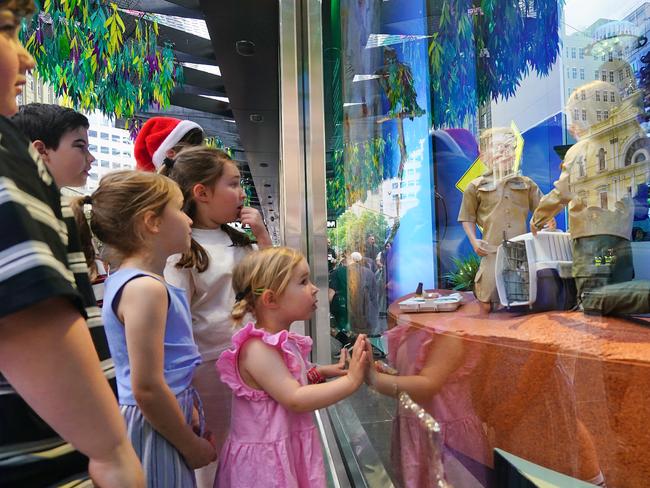 Excited children look on in awe at the Christmas windows. Picture: NewsWire / Luis Enrique Ascui