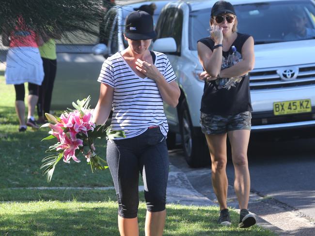 Shocked friends bring floral tributes to murder scene today.