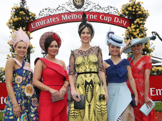 Four women wearing their finest strike a pose at the Melbourne Cup entrance. Picture: AAP Image/David Crosling