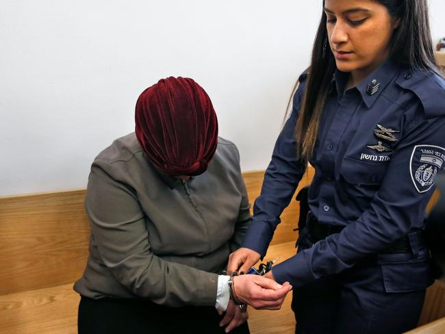 An Israeli policewoman removes handcuffs from Malka Leifer, a former Australian teacher accused of dozens of cases of sexual abuse of girls at a school. Picture: AFP