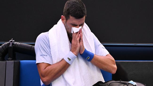 Djokovic uses a tissue during a break in his men's singles match on Friday night. Picture: William West / AFP