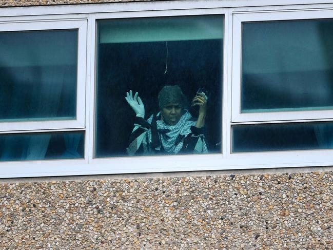 Following up on the lock down of Housing Commission towers in the inner city suburbs of North Melbourne and Flemington . Police block off all entry ways to the housing commission towers on Flemington Rd and Holland Crt. A women looks out of her window in the Tower at 120 Flemington Rd. . Picture: Sarah Matray