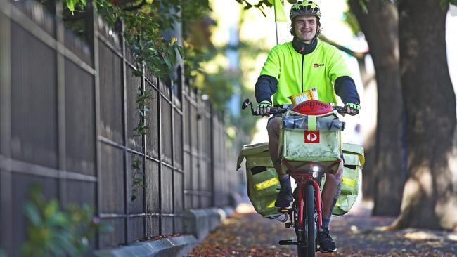 Australia Post delivery rider and Glenorchy football player, Aiden Grace is working hard during the COVID-19 pandemic. Picture: Zak Simmonds