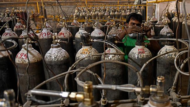 Workers are seen sorting oxygen cylinders that are being used for Covid-19 patients before dispatching them to hospitals at a facility on the outskirts of Amritsar in April. Picture: AFP