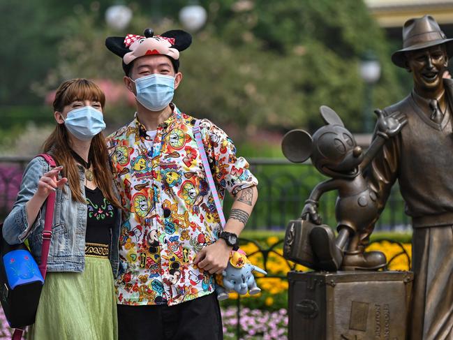 People wearing face masks visit the Disneyland amusement park in Shanghai. Picture: AFP