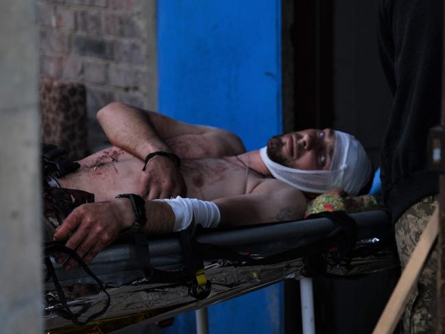 A wounded Ukrainian serviceman lies on a stretcher as he receives treatment at a stabilisation point near Bakhmut. Picture: AFP