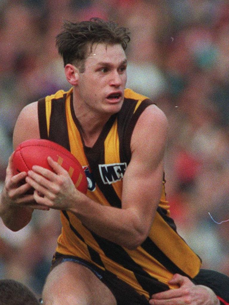 Crawford is tackled by Essendon's Joe Misiti during a match in 1997.