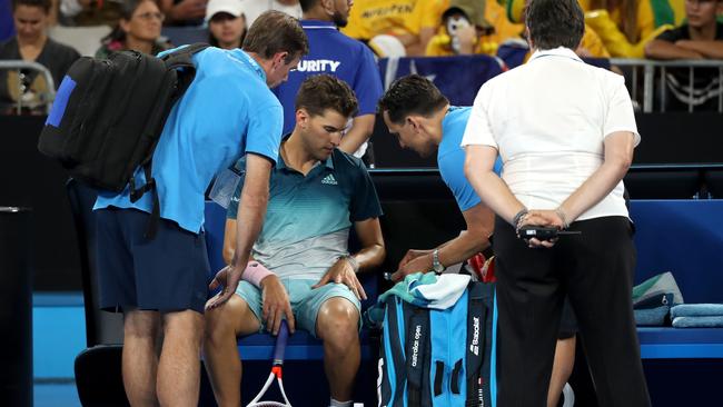 Dominic Thiem gets some treatment before retiring against Alexi Popyrin.