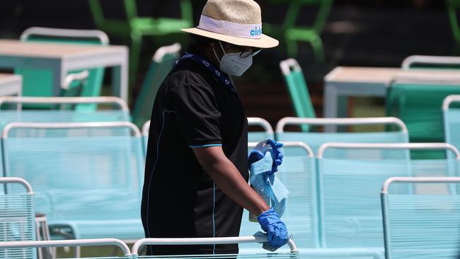 A worker disinfects a sitting area.