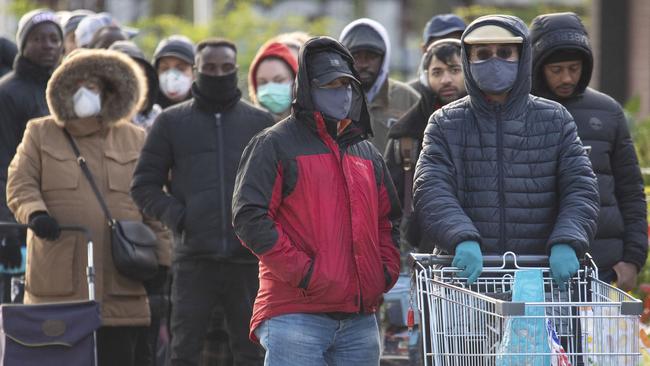 People queue outside a supermarket in London today. Picture: PA