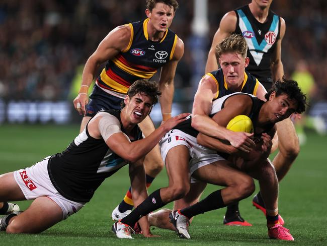 ADELAIDE, AUSTRALIA - MAY 02: Brayden Cook of the Crows tackles Jase Burgoyne of the Power during the 2024 AFL Round 08 match between the Adelaide Crows and the Port Adelaide Power at Adelaide Oval on May 02, 2024 in Adelaide, Australia. (Photo by James Elsby/AFL Photos via Getty Images)