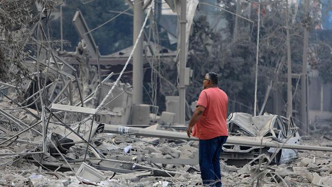 A man checks the damage along the old road leading to Beirut International airport on the outskirts of the capital. Picture: AFP