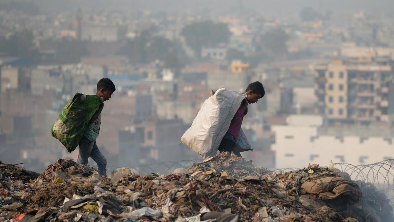 Indians carry bags with usable items after collecting them from a garbage dump at the Bhalswa landfill site in New Delhi. Picture: AFP