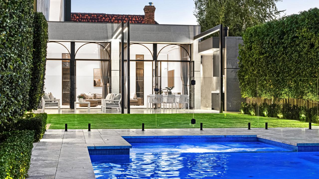 The gas-heated pool at Trinafour is framed by Paul Bangay gardens and Travertine paving, creating a five-star resort feel at home.