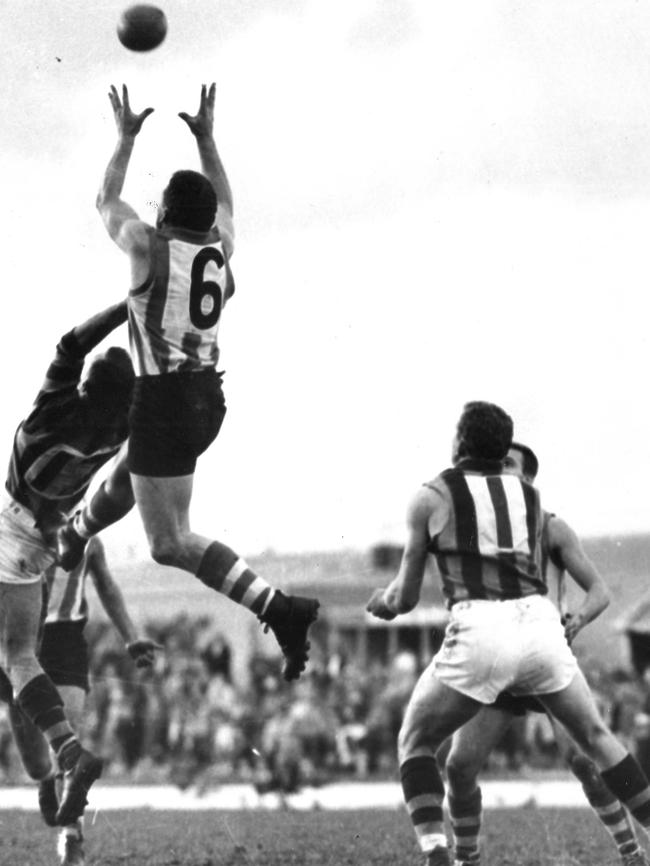 North Melbourne v Hawthorn in 1960. John Dugdale leaps over Noel Voigt.