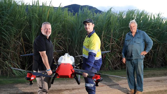 NQ Commercial Drone Services co-owners and commercial drone pilots Brian Maher, Gareth Henry and farmer Mark Savina with a large commercial drone designed to spray sugar cane crops to deliver a higher yield. Picture: Brendan Radke