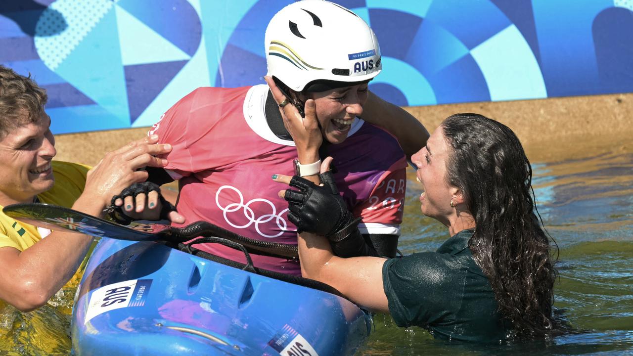 Jess Fox jumps into the water to celebrate with her sister. (Photo by Bertrand GUAY / AFP)