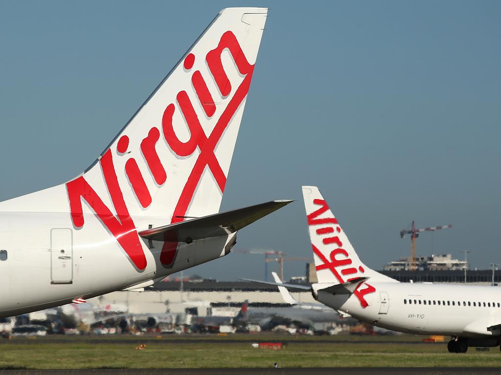 The Virgin Australia Holdings Ltd. logo is displayed on the tails of a Boeing Co. 737-800, left, and a Boeing Co. 737-8FE aircraft preparing to take off at Sydney Airport in Sydney, Australia, on Monday, Feb. 8, 2016. Virgin Australia is scheduled to announce half-year earnings on Feb. 11. Photographer: Brendon Thorne/Bloomberg