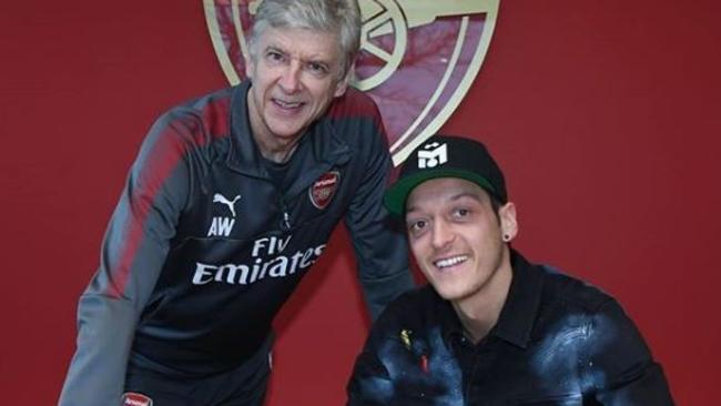 Mesut Ozil putting pen to paper on a new contract