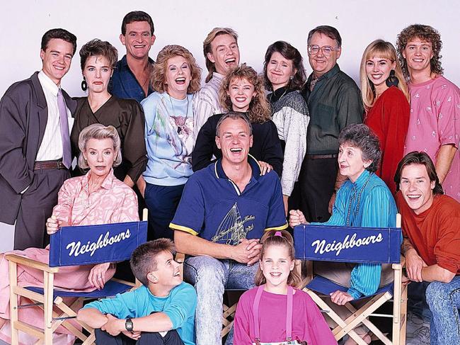 The cast of Neighbours in 1987: Stefan Dennis with Fiona Corke, Paul Keane, Anne Charleston, Jason Donovan, Kylie Minogue, Lisa Armytage, Ian Smith, Annie Jones, Craig McLachlan, (Front, left to right) Anne Haddy, Kristian Schmidt, Alan Dale, Katie Landers, Vivean Gray and Guy Pearce. 