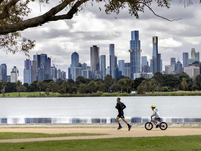 MELBOURNE, AUSTRALIA - NewsWire Photos October 11, 2021:  A man runs while his son cycles around Albert Park Lake during Melbournes 6th Covid lockdown. Picture: NCA NewsWire / David Geraghty