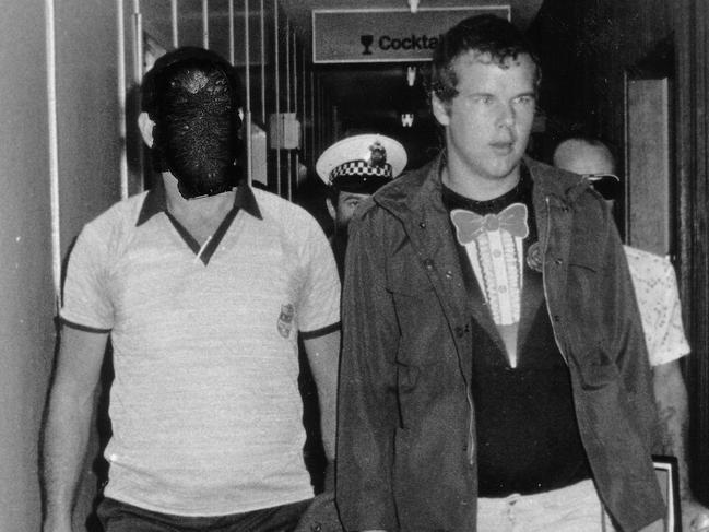 Murderer Andy Albury is led by detectives through the Darwin Airport. Albury was convicted of killing a woman in Darwin's Mitchell Street in November 1983 and mutilating her body. Circa: 8/1984.