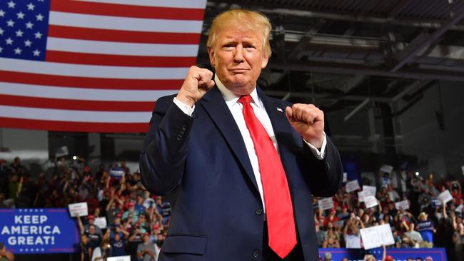 President Donald Trump pumps his fists as he arrives for a Make America Great Again rally at Minges Coliseum in Greenville, North Carolina.