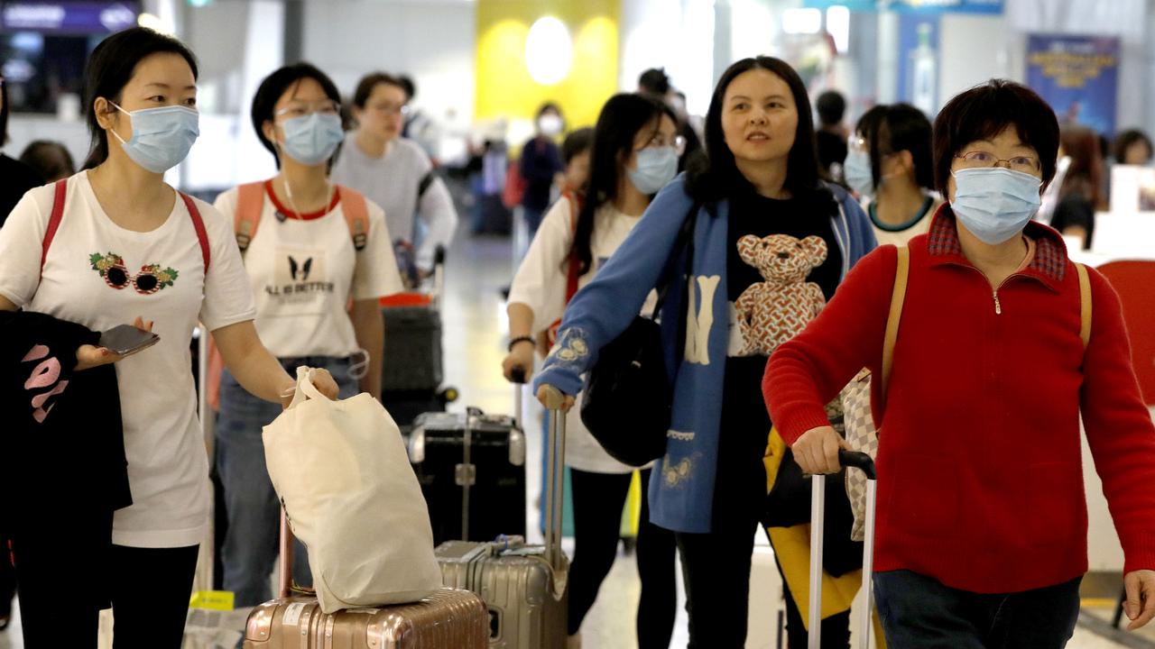 Travellers from Shanghai arriving last week at Sydney Airport don masks as they emerge from customs. Picture: Chris Pavlich.