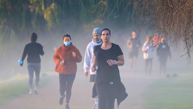 People exercise early morning around Albert Park as Melbourne continues its lockdown due to a cluster of Covid-19 cases. Picture: Ian Currie