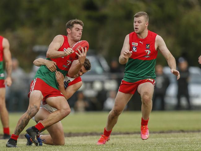 Pines player Brandon Lewis handballs as teammate Rhys Wilson looks on. Picture: Valeriu Campan