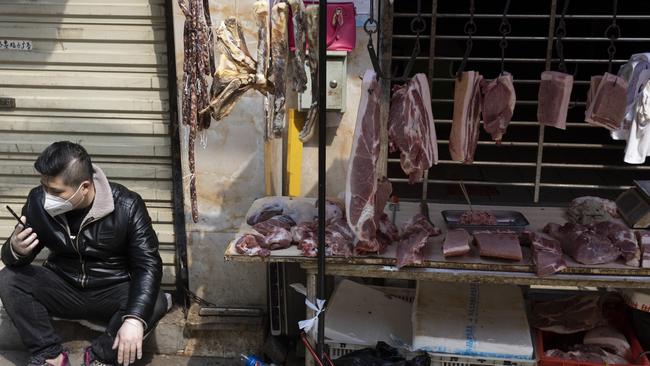 A vendor waits for customers at a stall near a still partially closed off wet market due to the coronavirus outbreak in Wuhan in central China's Hubei province on April 3. Picture: Ng Han Guan/AP