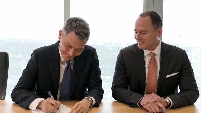 BHP chief executive Mike Henry (left) signs the contract with BHP chairman Ken MacKenzie. Picture: Supplied