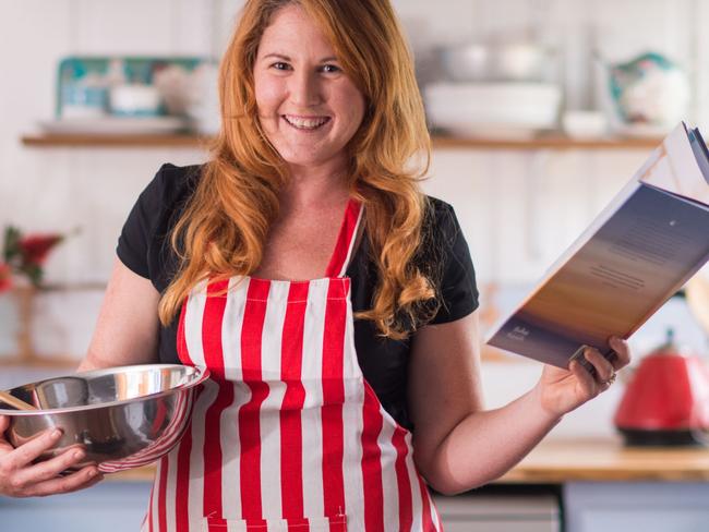 Angie Simms, author of Eat, Drink and Be Straddie, in her Stradbroke Island kitchen with her book, to be released on October 16.