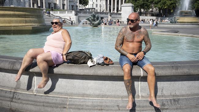 Sunbathers enjoy the cooling waters of fountains in Trafalgar Square in London earlier this year. A Northern Hemisphere heatwave could crunch energy supplies and send prices up every few years. Picture: Richard Baker/Getty