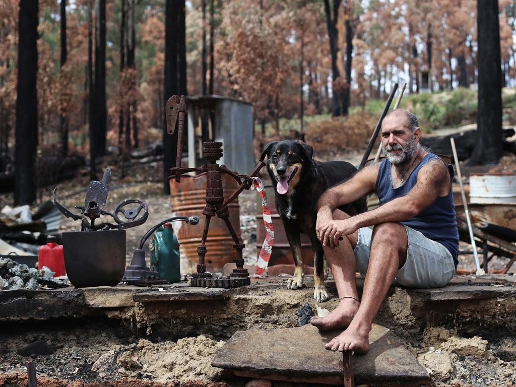 Dale "Hairy Man" Fullard with his dog, Lawson, at the site of his home on Southwood Rd that was destroyed in the bushfire. Picture: LUKE BOWDEN